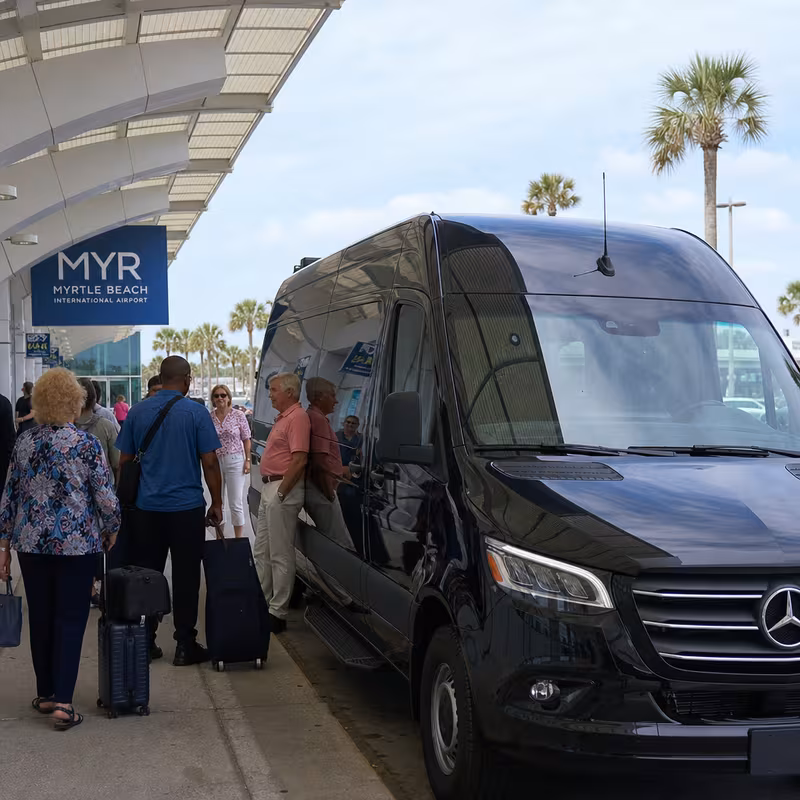 Group boarding a white charter bus for Airport Transportation transportation in Myrtle Beach