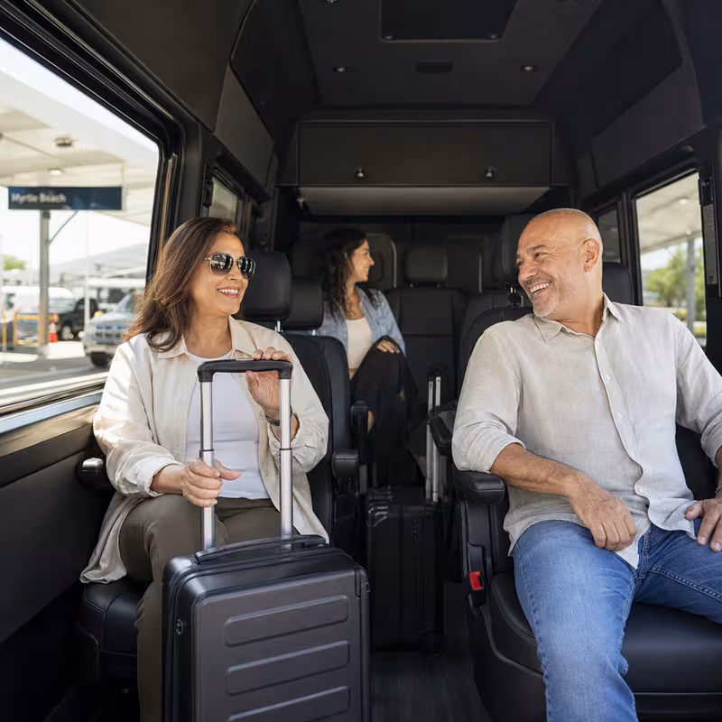Passengers loading luggage while boarding an Myrtle Beach group shuttle