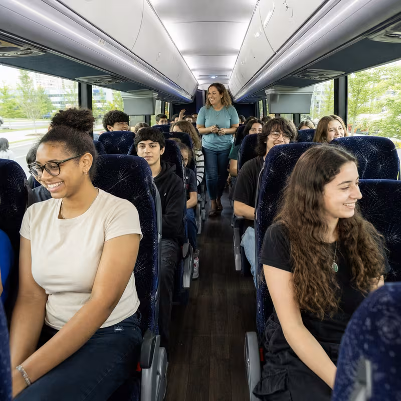Group boarding a white charter bus for School Transportation transportation in Myrtle Beach