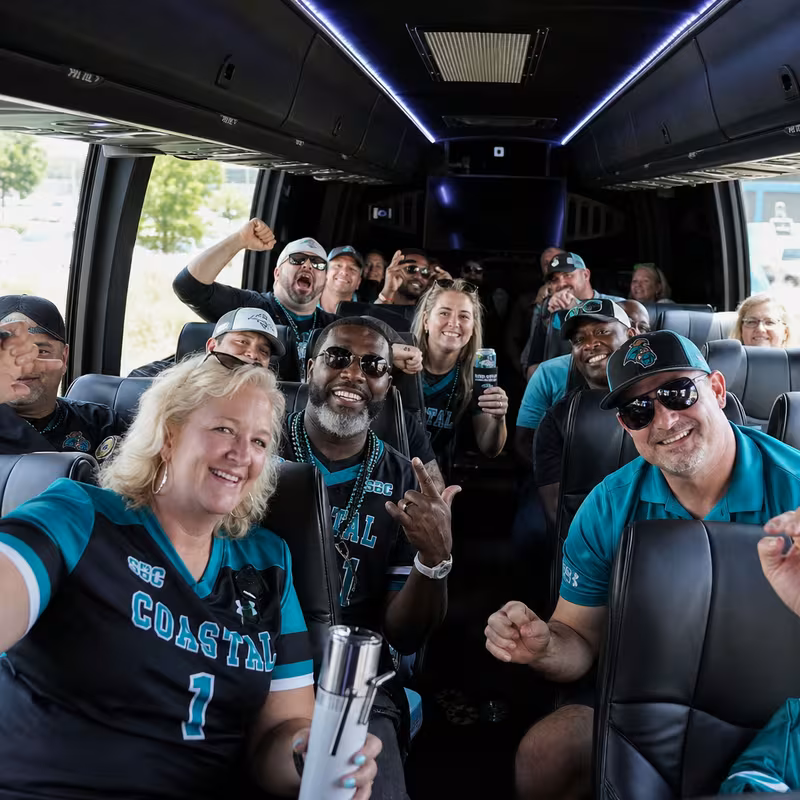 Group boarding a white charter bus for Sporting Event Transportation transportation in Myrtle Beach